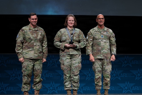 U.S. Space Force Chief of Space Operations Gen. Chance Saltzman, left, and Chief Master Sgt. of the Space Force John Bentivegna, right, recognize Maj. Adriane Payn at the Air Force Association’s Warfare Symposium in Aurora, Colo., Feb. 23, 2026. Payn was awarded the Character Award, one of four Guardian Values included in the Space Force’s annual Polaris Awards. (U.S. Air Force photo by Senior Airman Malia Heemsoth)