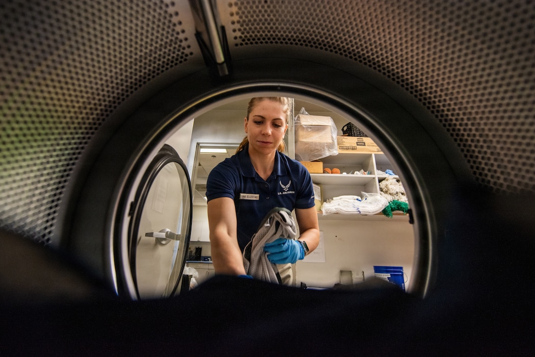 Airman removes laundry from dryer