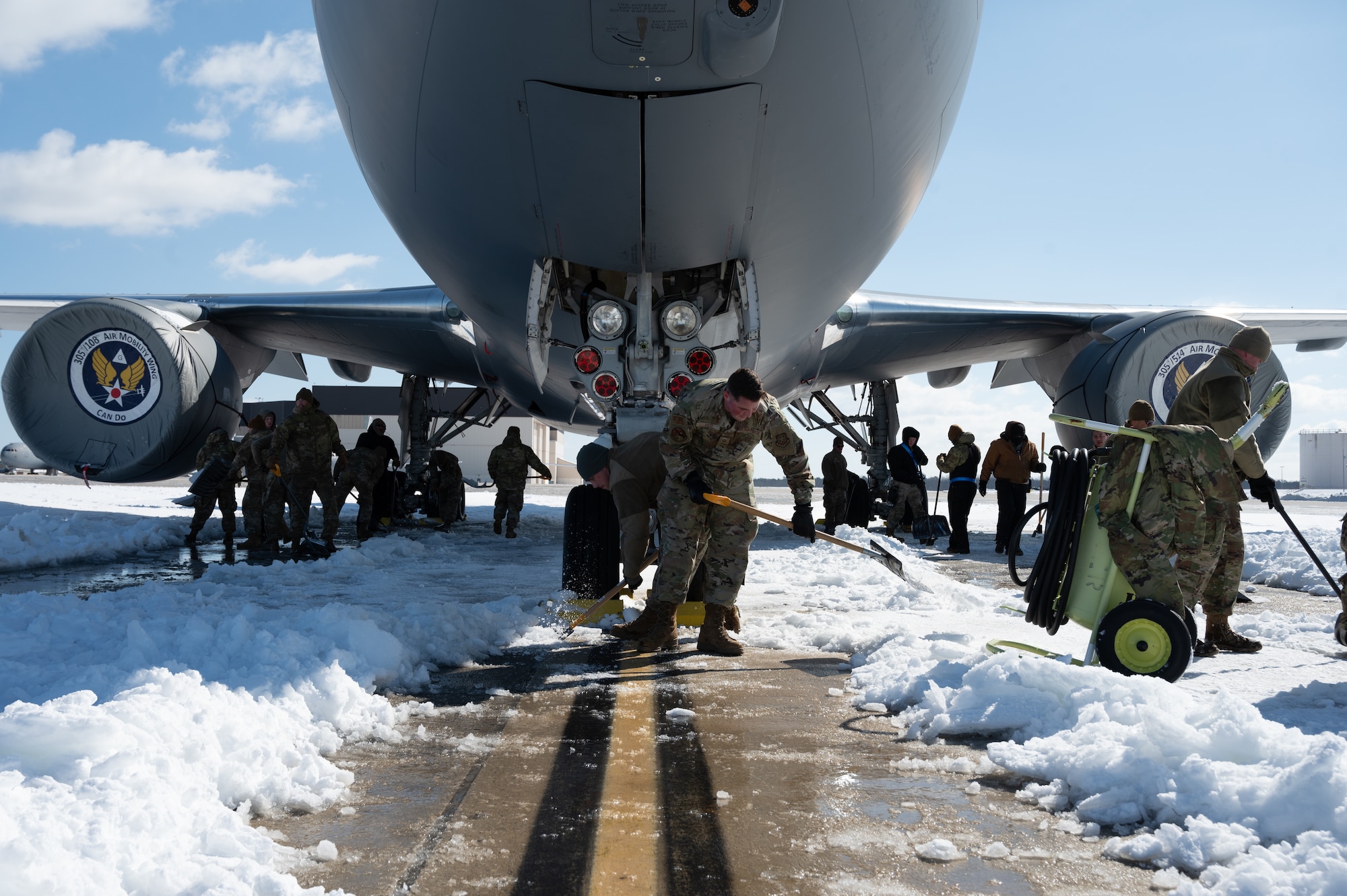 U.S. Air Force Airmen from the 305th Air Mobility Wing clear a path for a KC-46A Pegasus on Joint Base McGuire-Dix-Lakehurst, N.J., Feb. 24, 2026. Even in times of inclement weather, mission essential personnel maintained operational readiness of the base. (U.S. Air Force photo by Airman 1st Class Matthew Almazan)