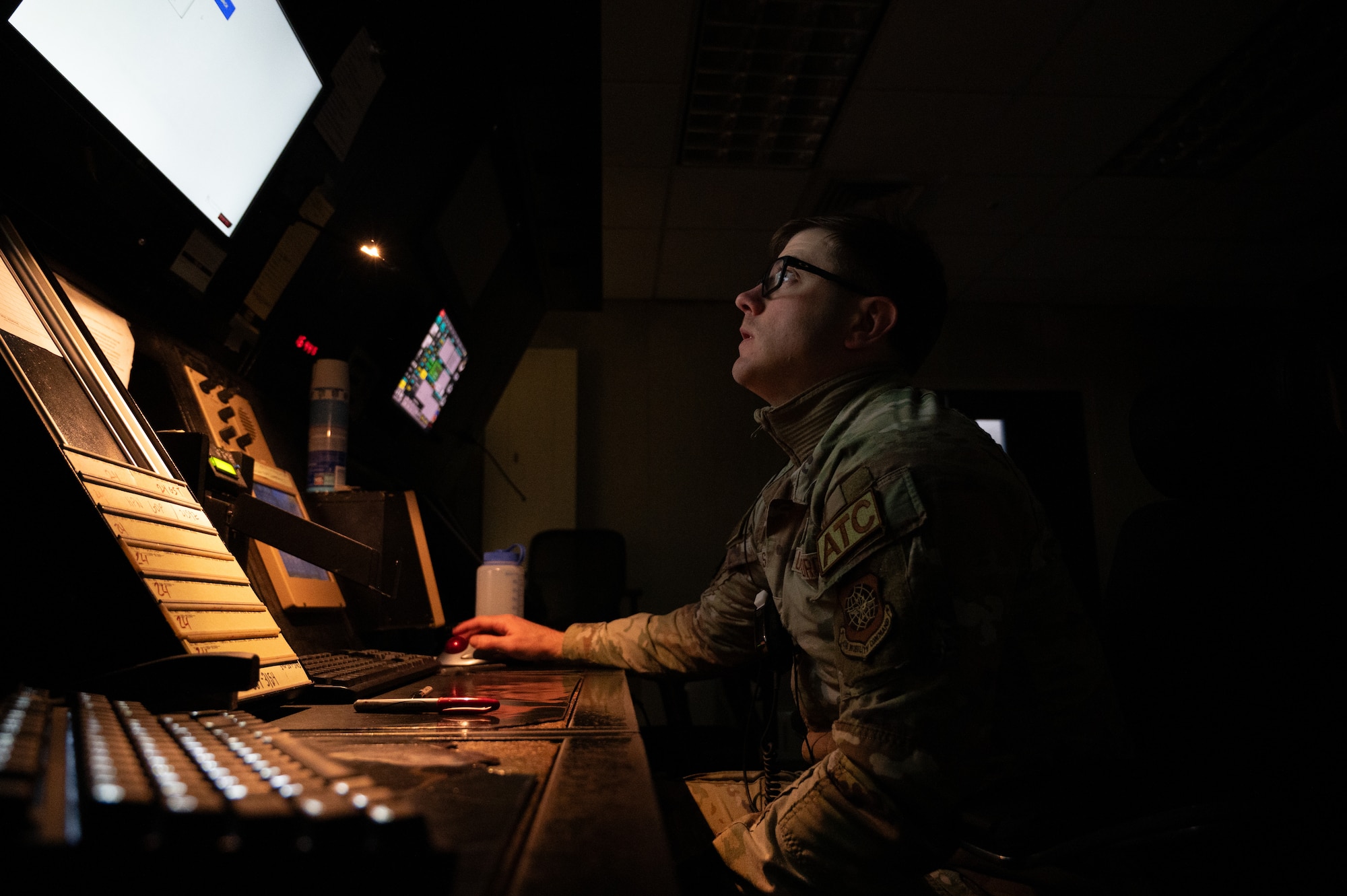 U.S. Air Force Senior Airman Caleb Osisek, 305th Operations Support Squadron air traffic controller, talks to aircrew while reading flight plans on Joint Base McGuire-Dix-Lakehurst, N.J., Feb. 24, 2026. Even in times of inclement weather, mission essential personnel maintained operational readiness of the base. (U.S. Air Force photo by Airman 1st Class Matthew Almazan)