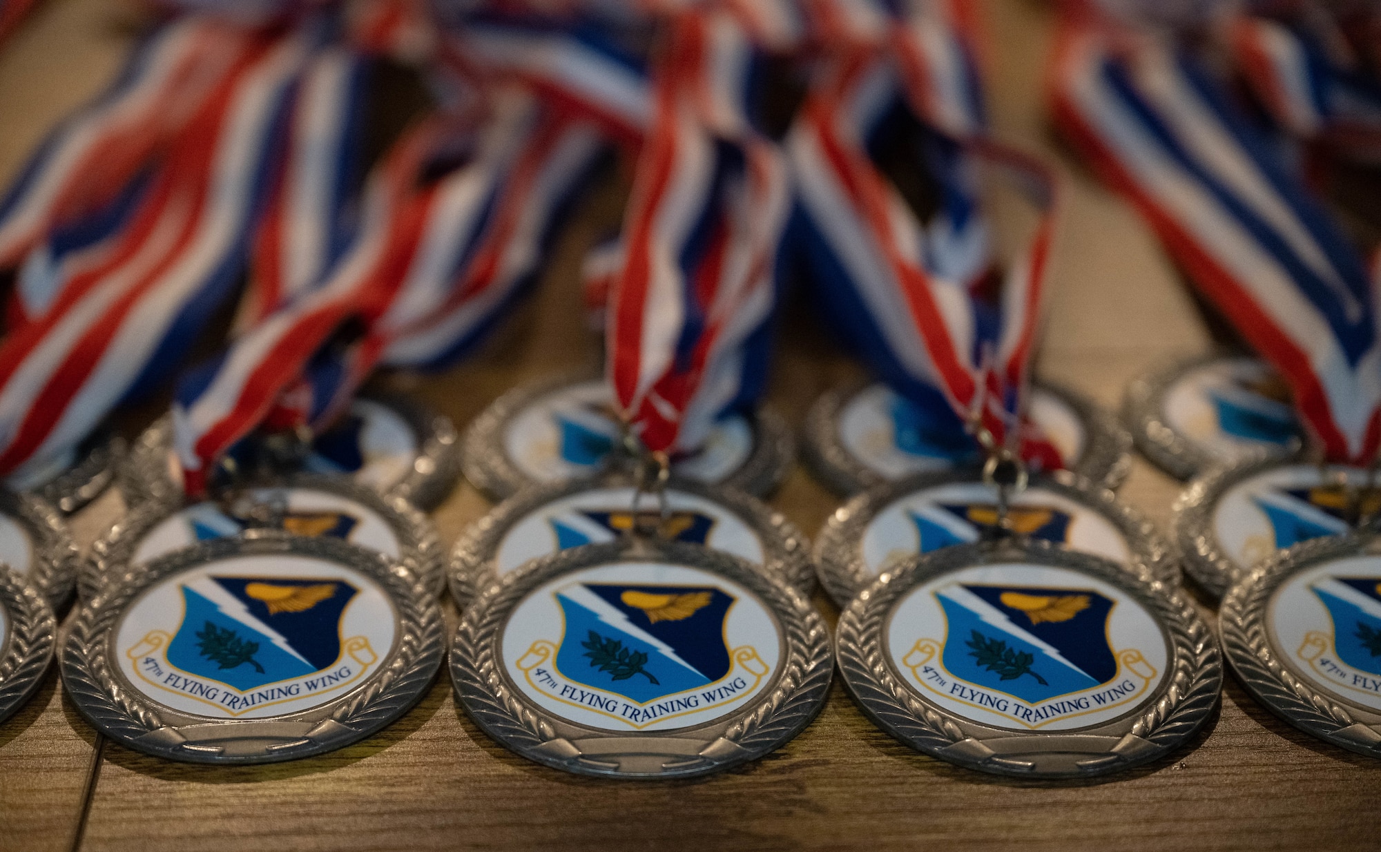 Rows of medallions sit atop a table prior to the 47th Flying Training Wing Annual Awards ceremony at Laughlin Air Force Base, Texas, Feb. 20, 2026. Nominees for annual awards wore the medallions as recognition during the ceremony. (U.S. Air Force photo by Airman 1st Class Darryl Keith)
