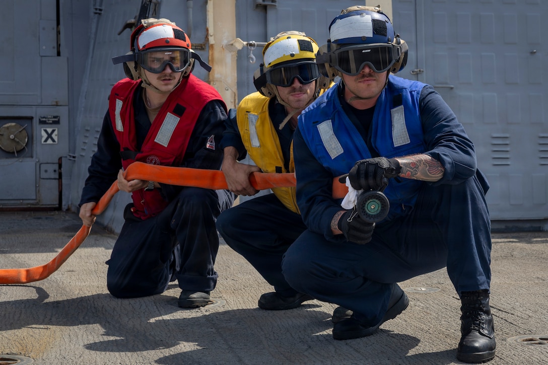 U.S. Navy Seaman Carson Barber, left, Boatswain’s Mate 2nd Class Carson Warren, middle, and Boatswain’s Mate 2nd Class Caleb Lebreton, assigned to Arleigh Burke-class guided-missile destroyer USS Delbert D. Black (DDG 119), man the hose during a flight deck firefighting drill in the Red Sea, Feb. 16, 2026. Delbert D. Black is deployed to the U.S. 5th Fleet area of operations to support maritime security and stability in the Middle East. (U.S. Navy photo by Mass Communication Specialist 1st Class Wendy Arauz)