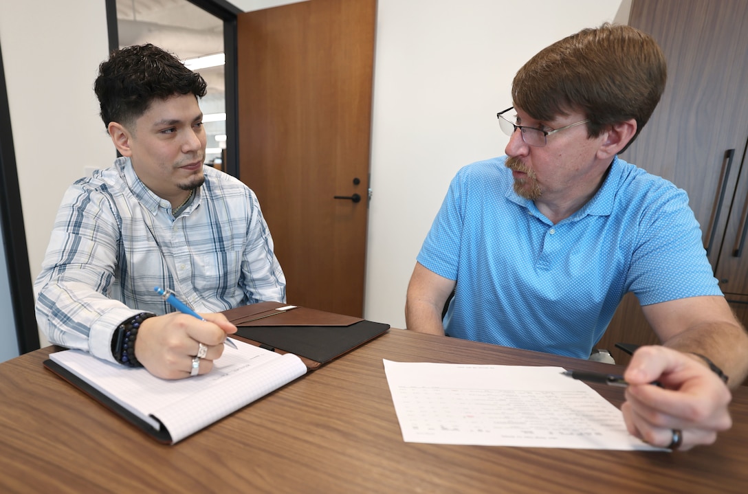 Roger Morejon, U.S. Army Corps of Engineers, Mobile District civil engineer with the Water and Wastewater Center for Expertise (TCX), gets instructions on a current project from his supervisor, Justin O’Donnell, Chief of the Water and Wastewater TCX at the Mobile District Headquarters, Mobile, Alabama, Feb. 25, 2026. With the support of his wife and family, Morejon obtained his Professional Engineer license in 2025. (U.S. Army photo by Chuck Walker)