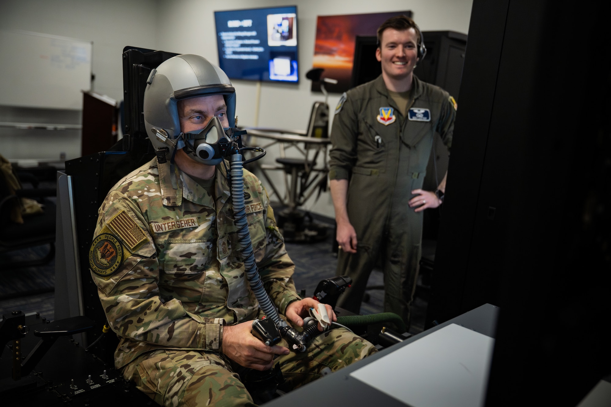 Chief Unterseher sits in the flight simulator with a breathing device on his face