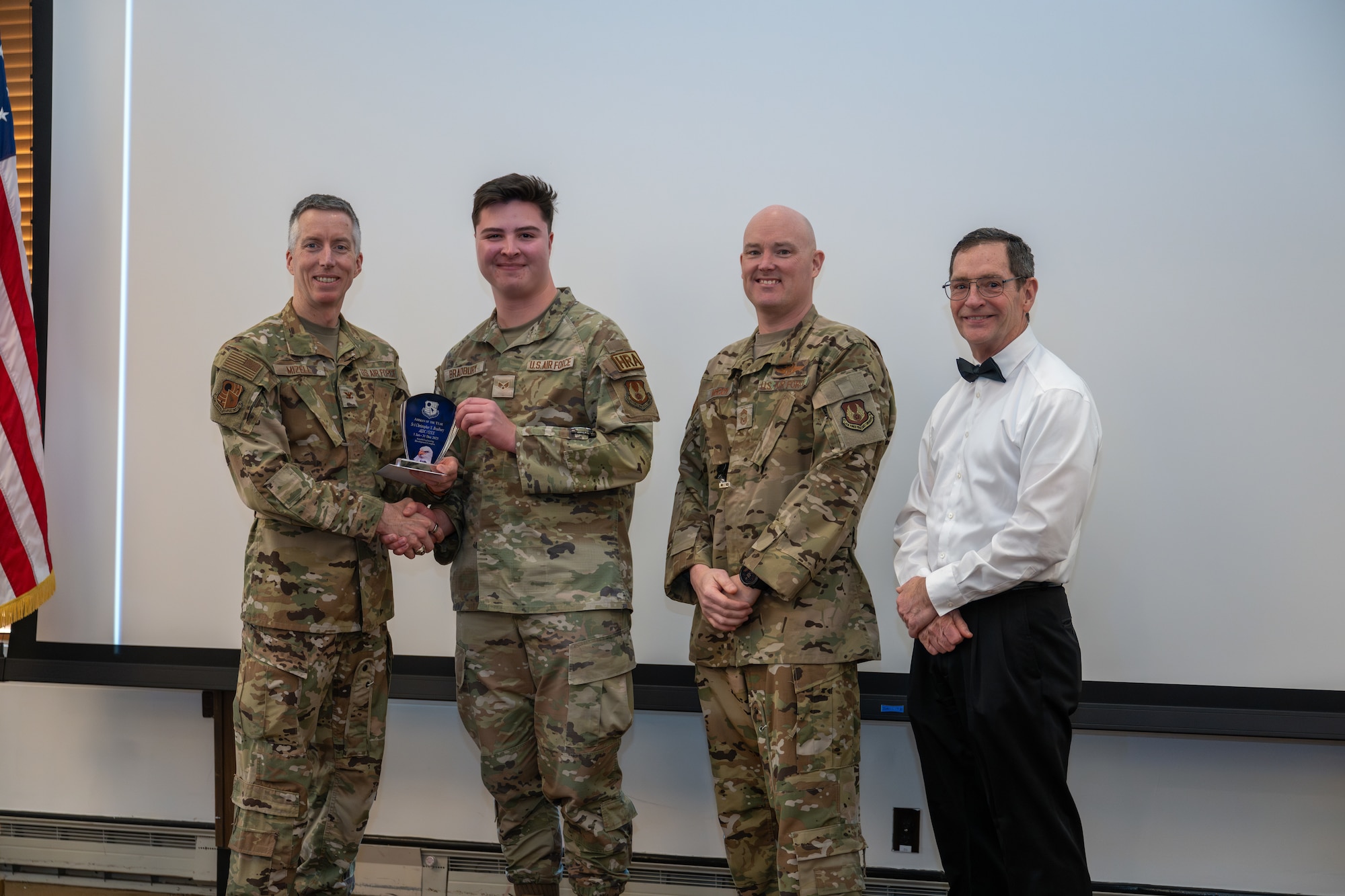 Senior Airman Christopher Bradbury, Command Chief Executive, accepts the award for Airman of the Year from Arnold Engineering Development Complex Commander Col. Grant Mizell during the AEDC Annual Awards ceremony Feb. 20, 2026, at Arnold Air Force Base, Tenn. Also pictured is Chief Master Sgt. Evan McCoy and AEDC Deputy Director Kevin Muckerheide. (U.S. Air Force photo by Keith Thornburgh)
