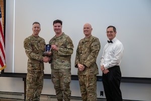 Senior Airman Christopher Bradbury, Command Chief Executive, accepts the award for Airman of the Year from Arnold Engineering Development Complex Commander Col. Grant Mizell during the AEDC Annual Awards ceremony Feb. 20, 2026, at Arnold Air Force Base, Tenn. Also pictured is Chief Master Sgt. Evan McCoy and AEDC Deputy Director Kevin Muckerheide. (U.S. Air Force photo by Keith Thornburgh)