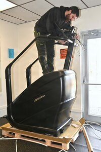 An employee of Coastal Fit Supply in Mays Landing, New Jersey, sets up a new piece of gym equipment at Blue Mountain Sports Area at Fort Indiantown Gap, Pennsylvania, on Feb. 26, 2026. (Pennsylvania National Guard photo by Brad Rhen)
