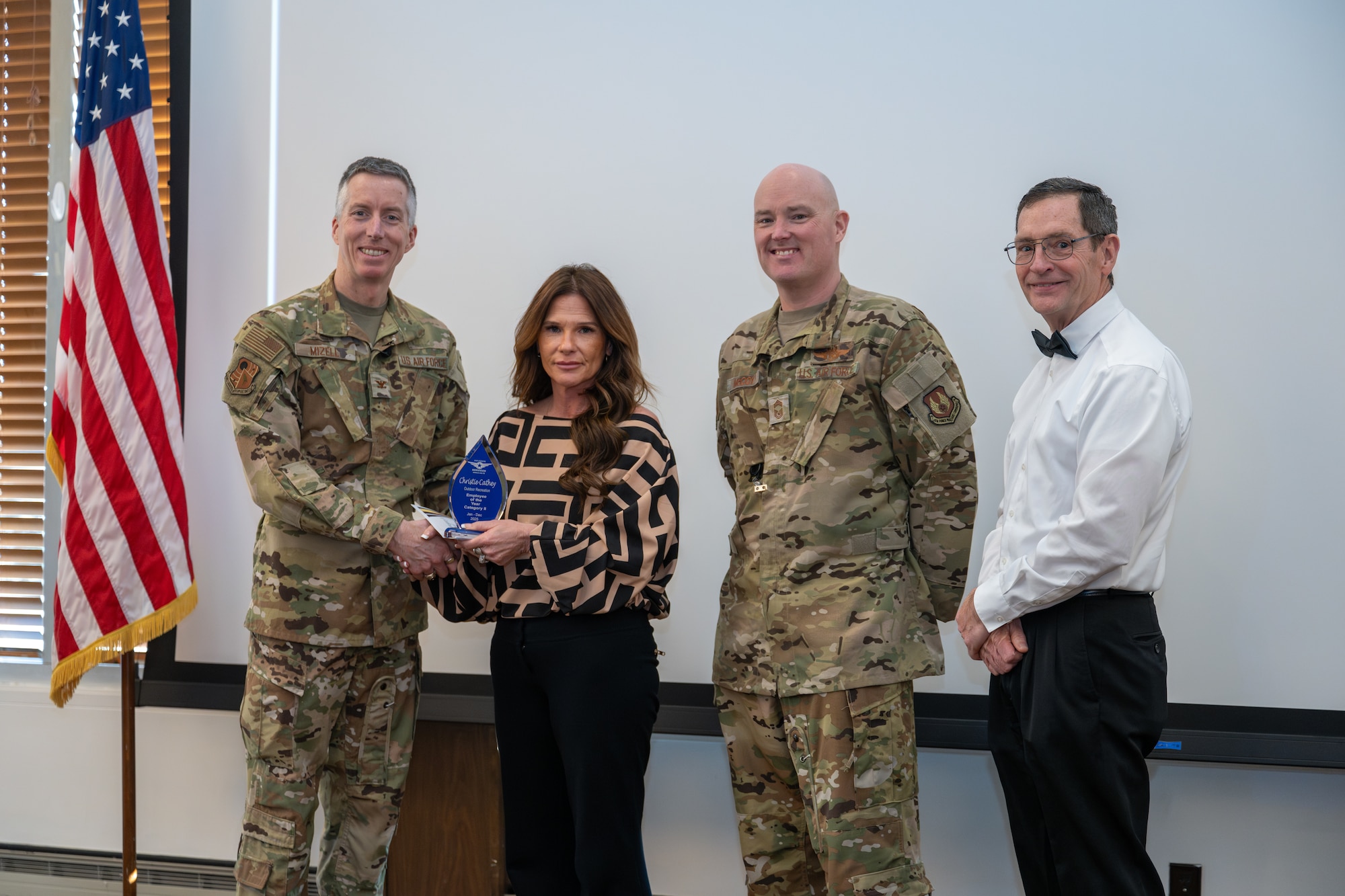 Christie Cathey with Test Support Division – Services accepts the award for Non-appropriated Fund Category II Civilian of the Year from Arnold Engineering Development Complex Commander Col. Grant Mizell during the AEDC Annual Awards ceremony Feb. 20, 2026, at Arnold Air Force Base, Tenn. Also pictured is Chief Master Sgt. Evan McCoy and AEDC Deputy Director Kevin Muckerheide. (U.S. Air Force photo by Keith Thornburgh)