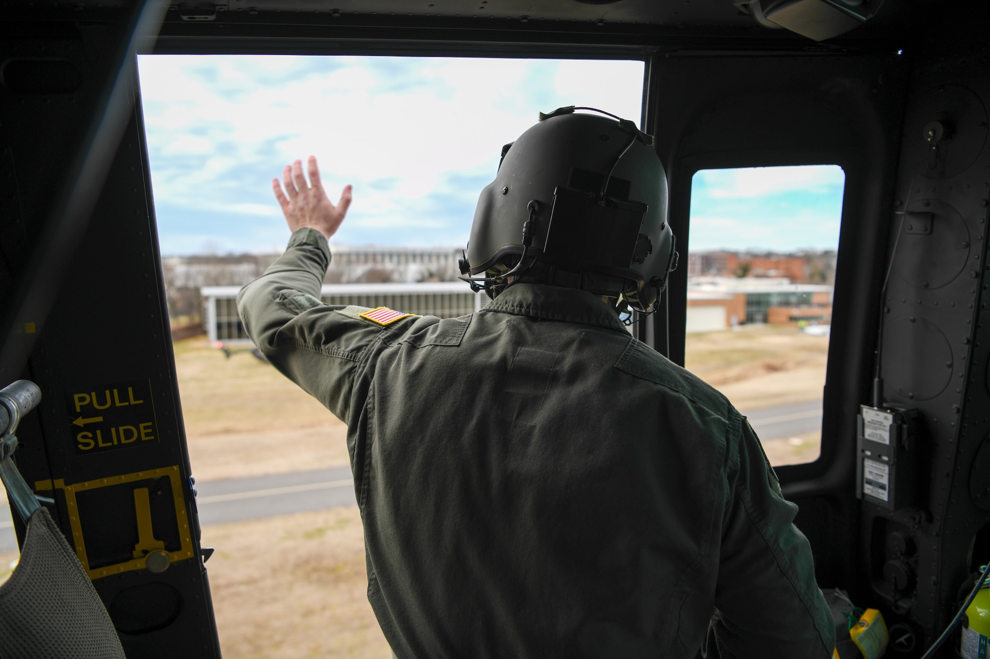 Service members looks out from helicopter