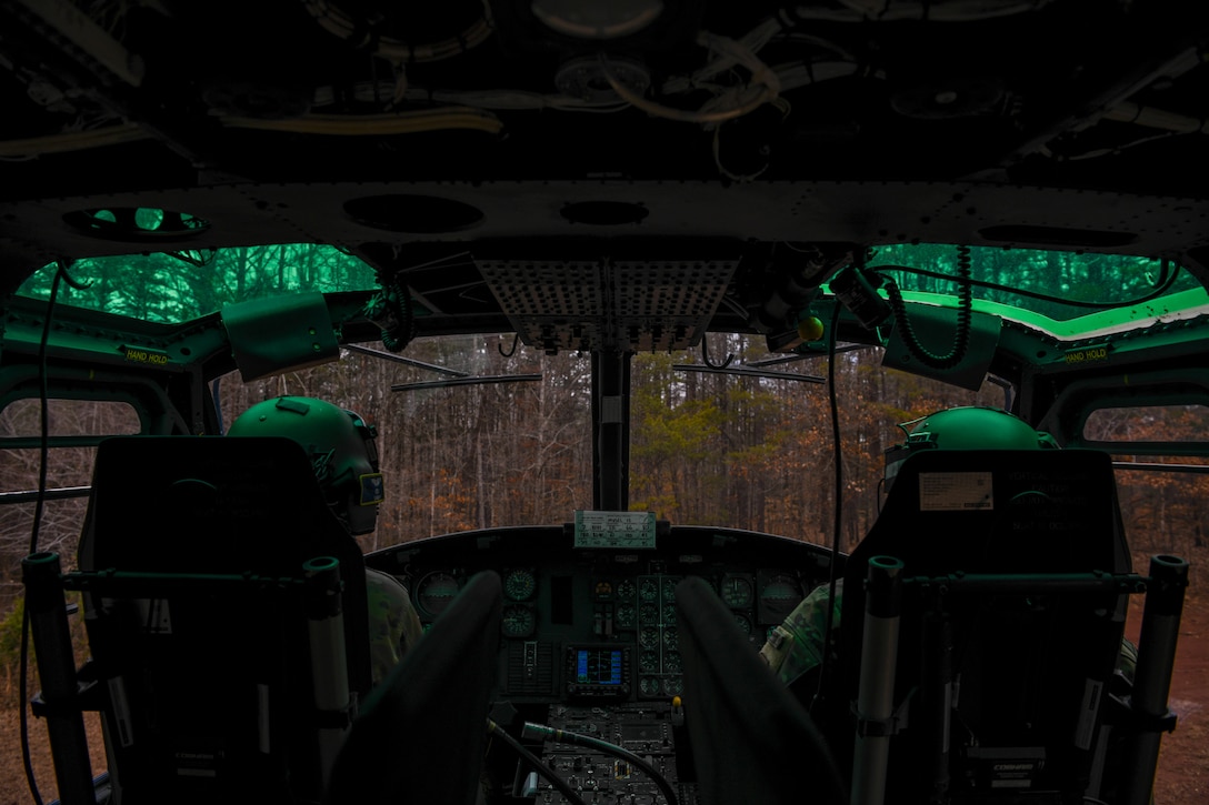 Service members looks out from helicopter