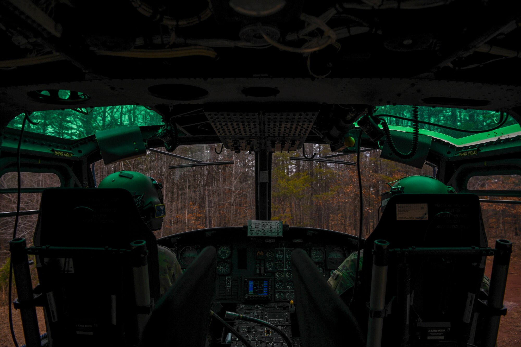 Service members looks out from helicopter