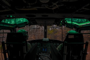 Service members looks out from helicopter