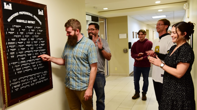 Ryan Wigner, civil engineer in the U.S. Army Corps of Engineers Nashville District Water Management Section, affixes his nameplate onto the “Registered Professional Personnel” board Feb. 20, 2026, at the district headquarters in Nashville, Tennessee. He couldn’t be present for the official ceremony, so his team recognized his achievement early. (USACE Photo by Lee Roberts)