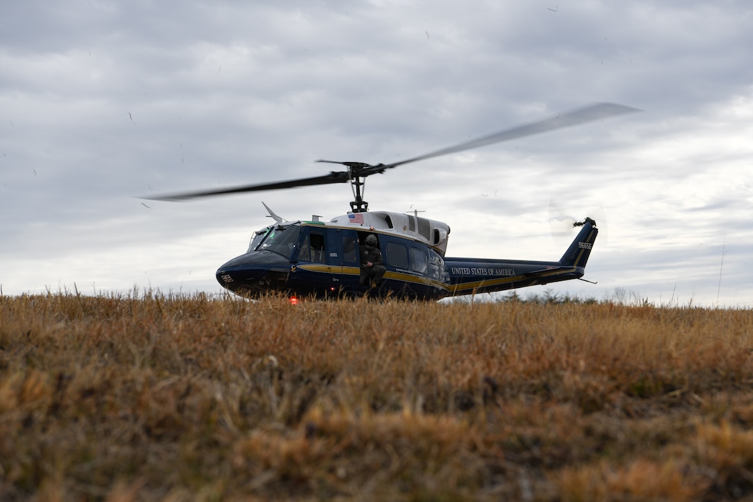 Service members looks out from helicopter