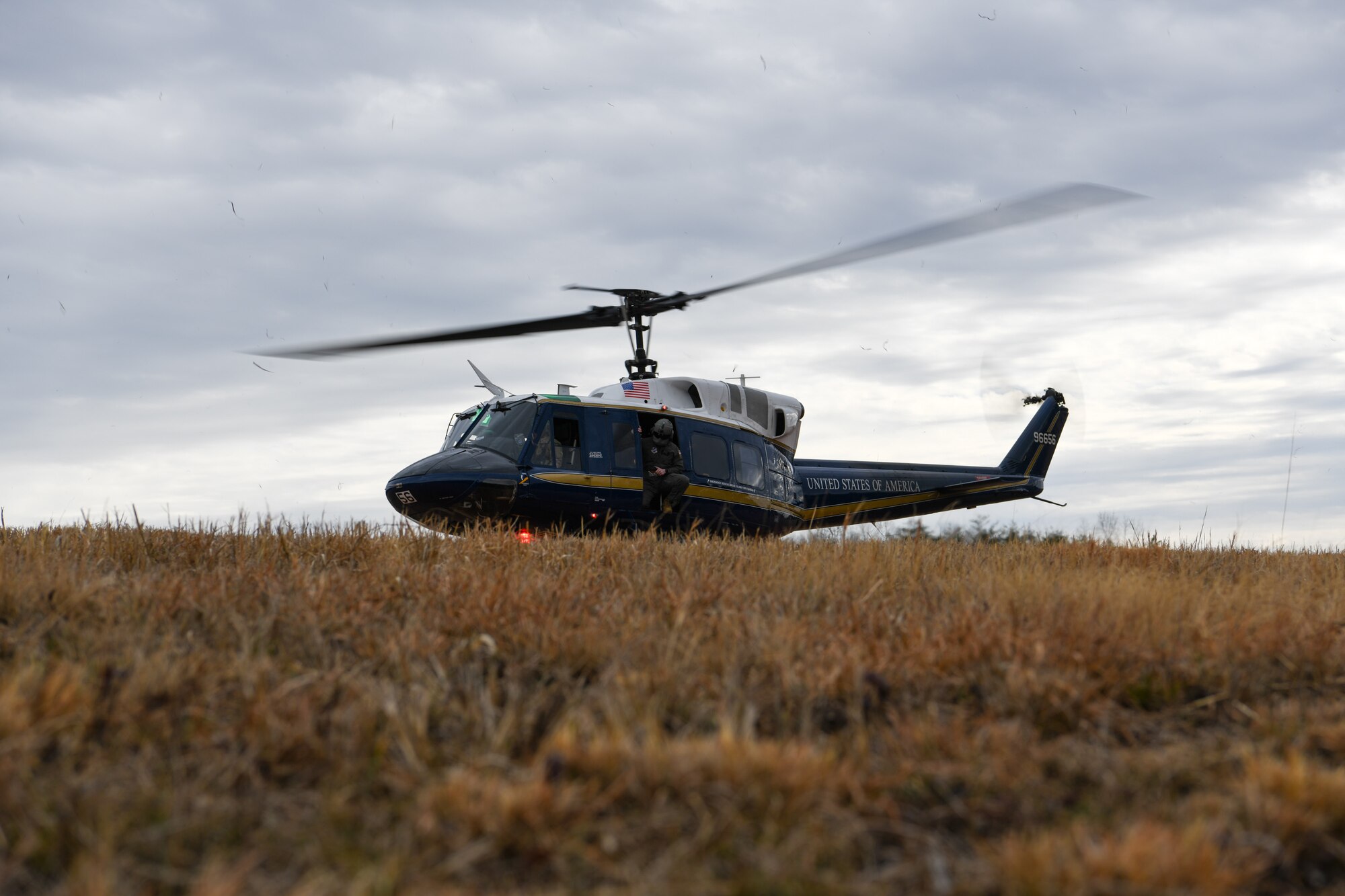 Service members looks out from helicopter