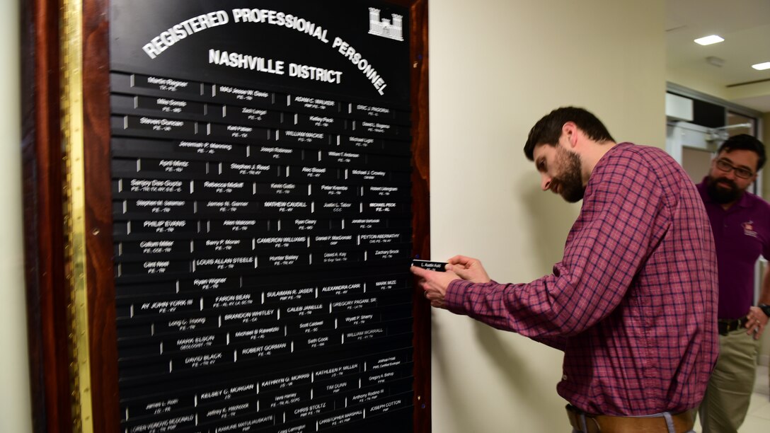 Austin Auld, civil engineer in the Water Management Section, who passed his Professional Engineering (PE) exam in the state of Tennessee, affixes his nameplate onto the “Registered Professional Personnel” board Feb. 25, 2026, at the district headquarters in Nashville, Tennessee. (USACE Photo by Lee Roberts)