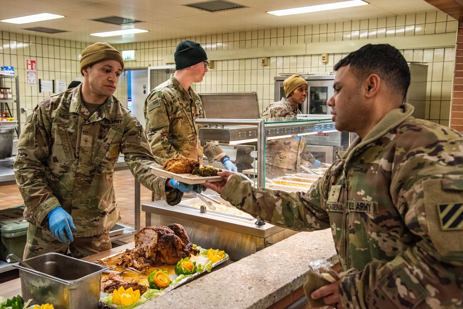 men in uniform serve food to another person in uniform