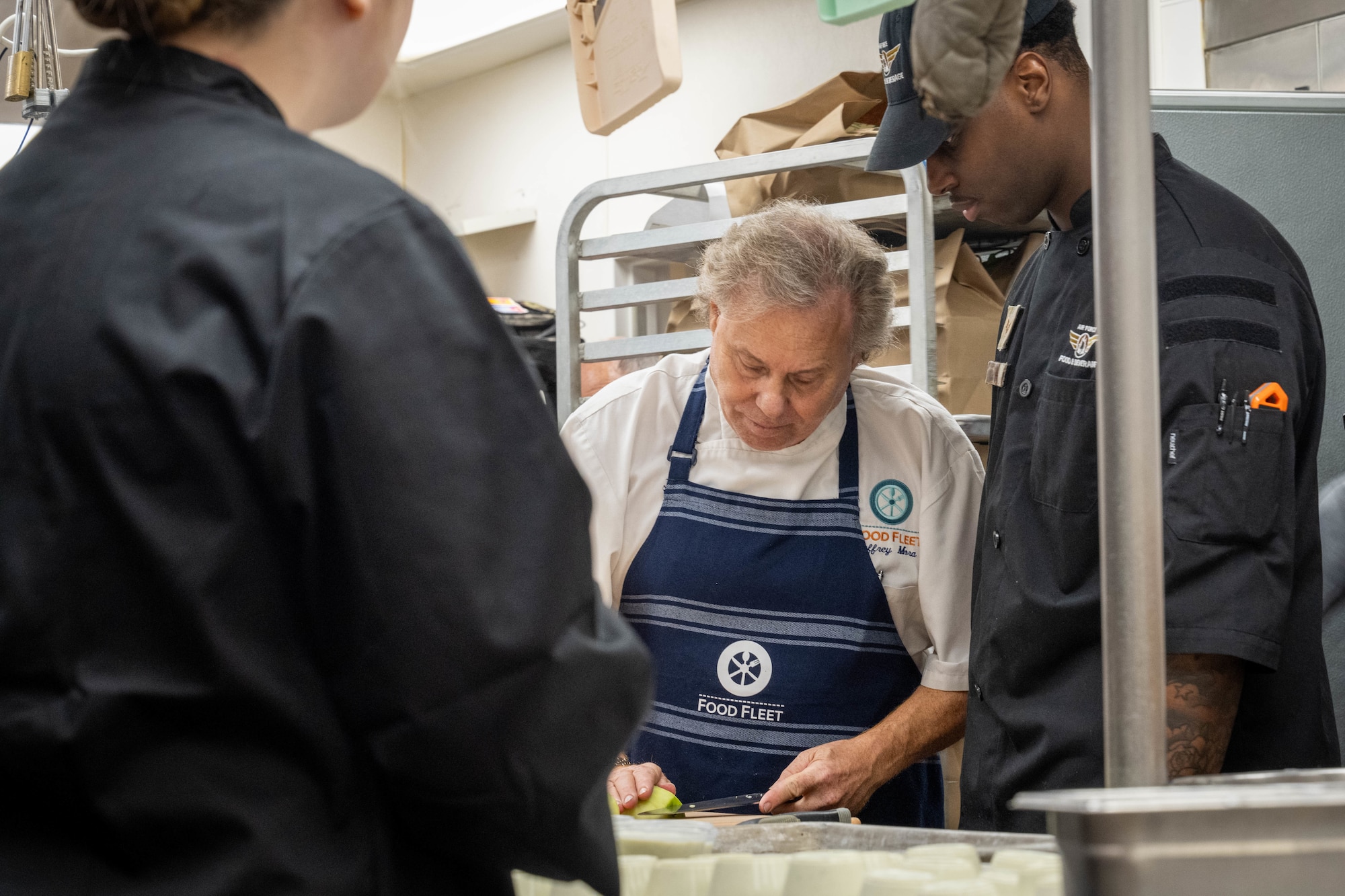 Master Chef Jeffery Mora, CEO of Food Fleet, teaches Senior Airman Robert Phifer, 673d Force Support Squadron food service apprentice, how to prepare apples during a mentorship event at the Marriott Anchorage Downtown, Alaska, Feb. 13, 2026. The week-long event allows Airmen and Soldiers to learn from master chefs from across the nation, expanding and developing technical expertise within their career field. (U.S. Air Force photo by Airman 1st Class Owen Davies)