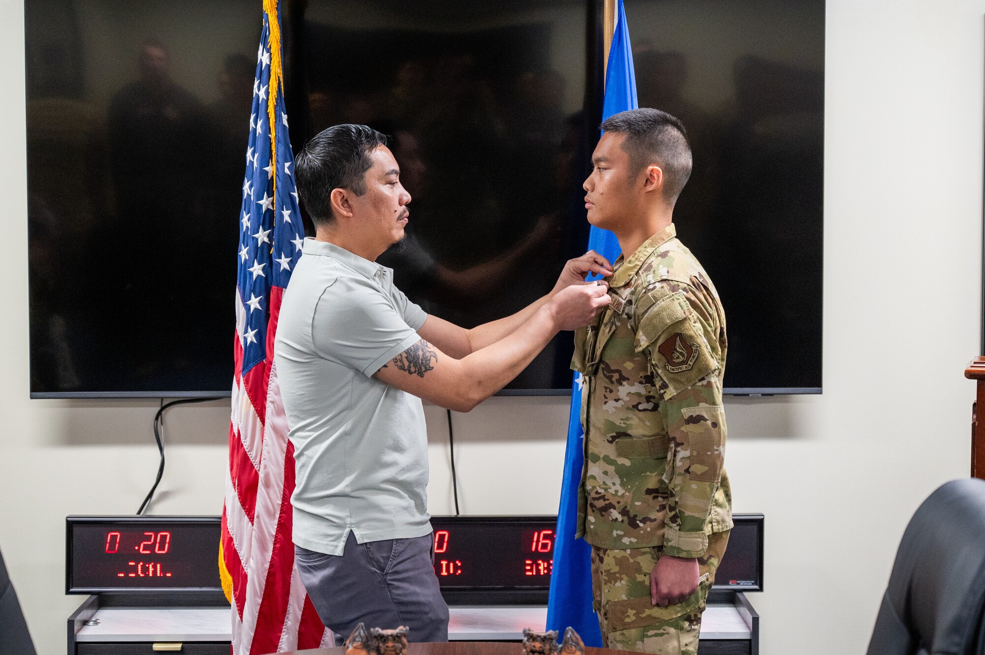 Retired U.S. Air Force Senior Master Sgt. Jose Libunao, left, pins a ribbon on his son, Senior Airman Angelo Libunao, during a ceremony at Kadena Air Base, Feb. 19, 2026. Libunao now serves in the same Aeromedical Evacuation squadron where his father and uncle were assigned, continuing a family tradition of service in the Indo-Pacific. (U.S. Air Force photo by Airman 1st Class Francisco Huerta)