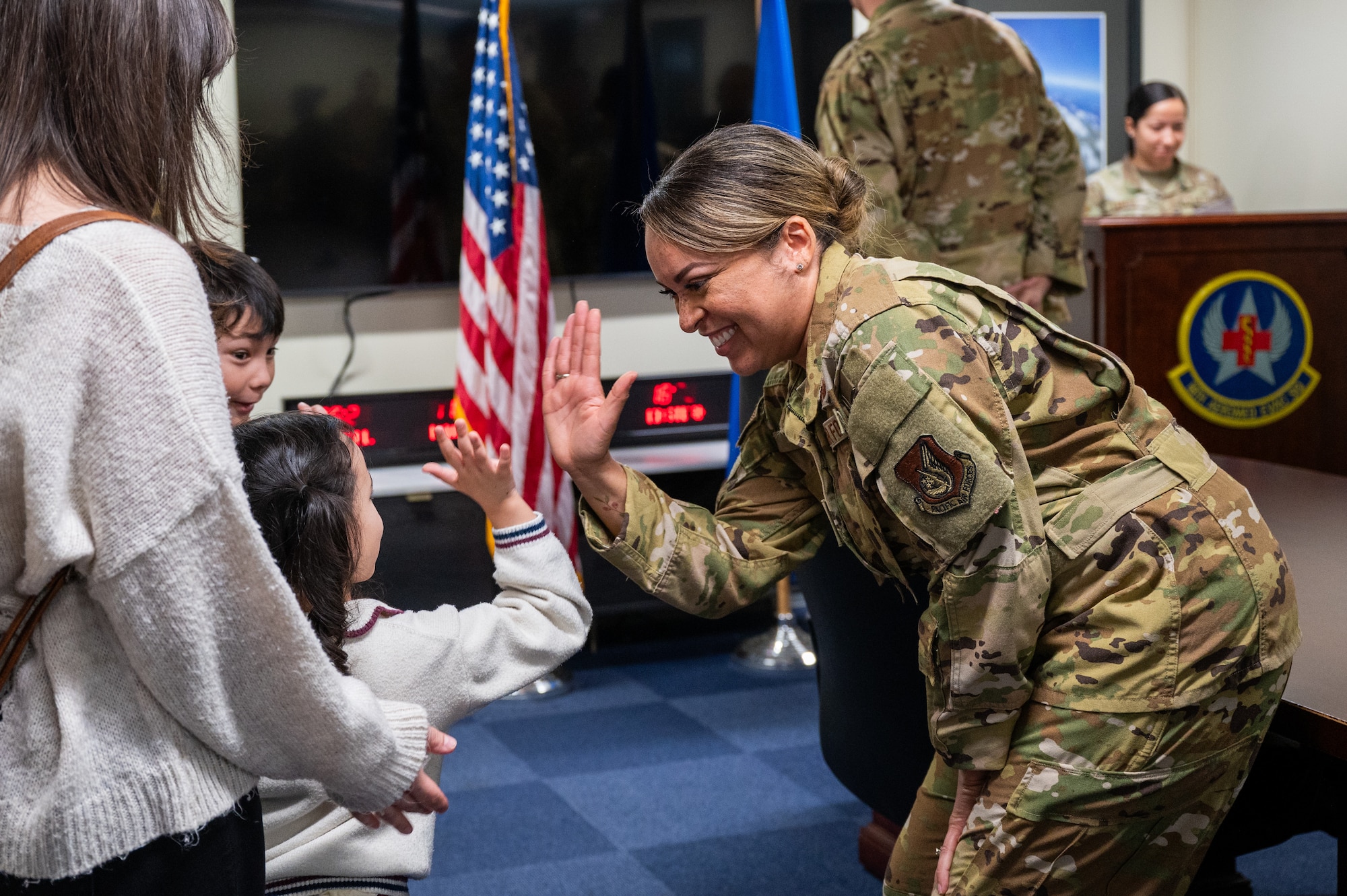 U.S. Air Force Col. Jeanae Jackson, 18th Aeromedical Evacuation Squadron commander high-fives a sibling of Senior Airman Angelo Libunao following a recognition ceremony at Kadena Air Base, Feb. 19, 2026. Libunao became the third member of his family to serve in the 18th Aeromedical Evacuation Squadron, continuing a multigenerational legacy of service at Kadena. (U.S. Air Force photo by Airman 1st Class Francisco Huerta)