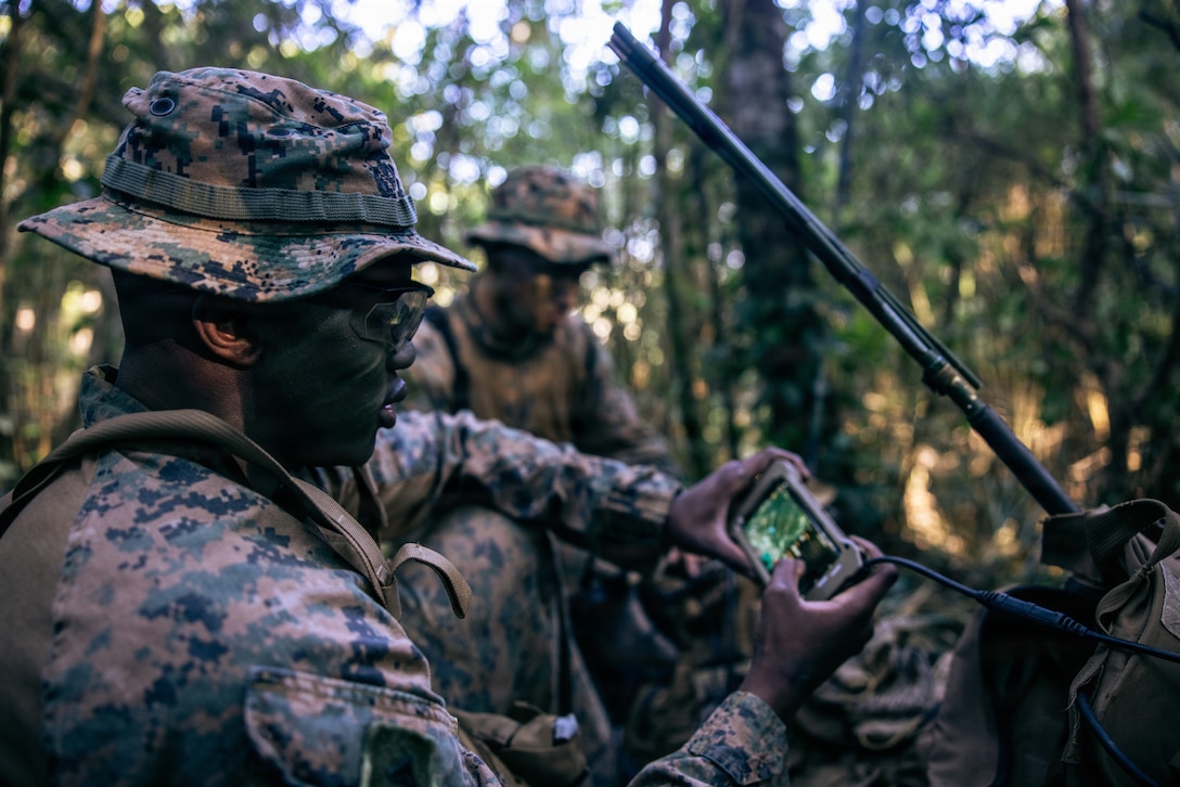 A U.S. Marine with 7th Communication Battalion, III Marine Expeditionary Force Information Group, plots points for a hike during a jungle training event at Camp Hansen, Okinawa, Japan, Feb. 4, 2026. The training focused on small-unit tactics, sustainment, camouflage and survivability skills to enhance operational readiness in austere environments. (U.S. Marine Corps photo by Cpl. Meshaq Hylton)