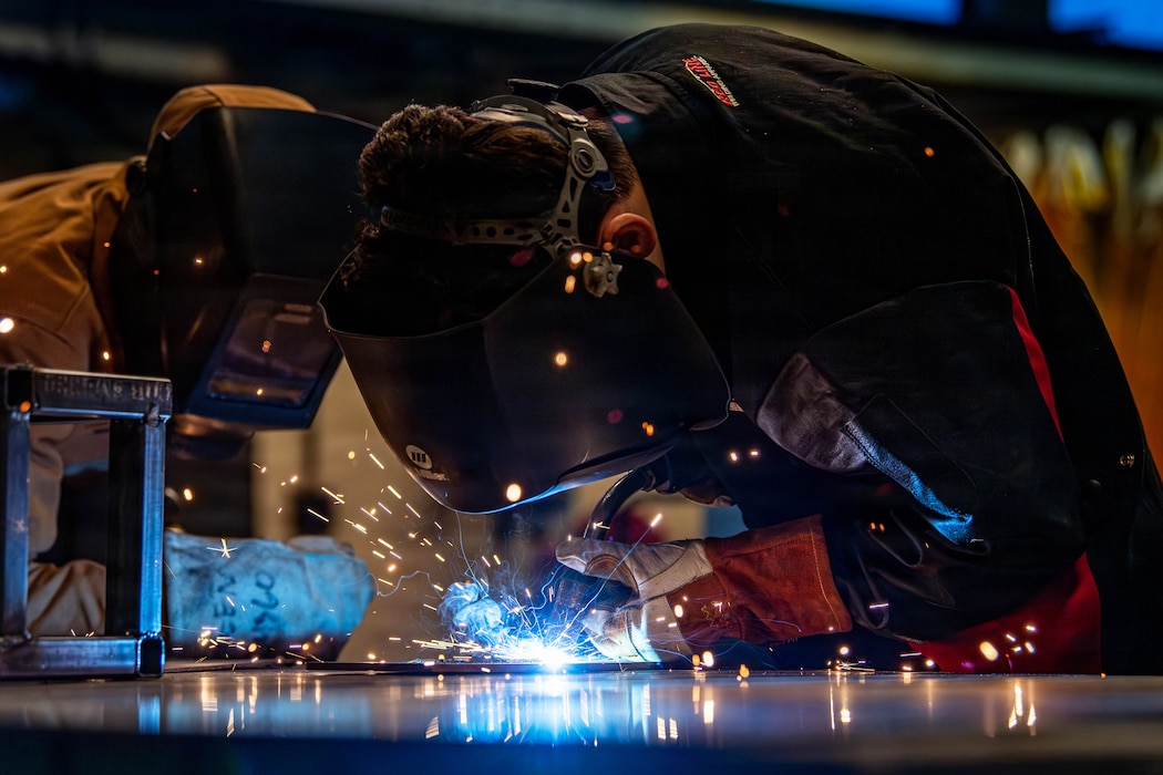 Airmen welding metal