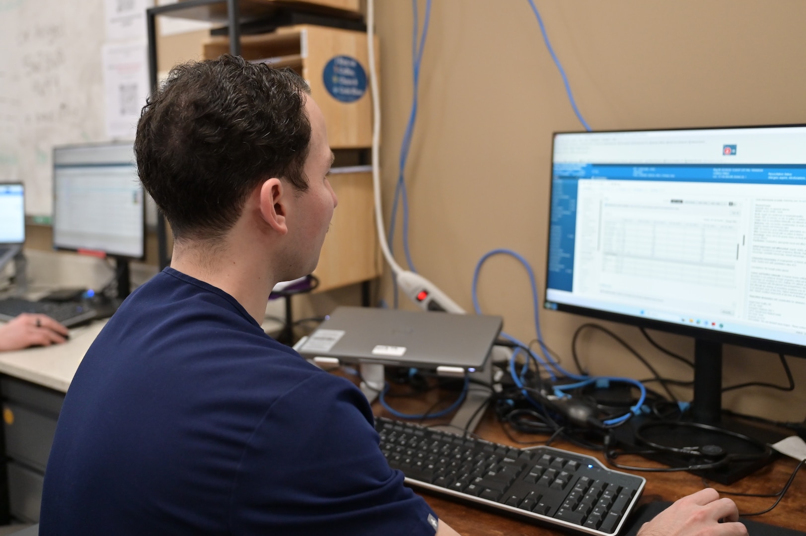 A resident physician reviews patient information in the emergency department at Carl R. Darnall Army Medical Center. Residents balance long hours and intensive training while providing care to service members, retirees, and their families.