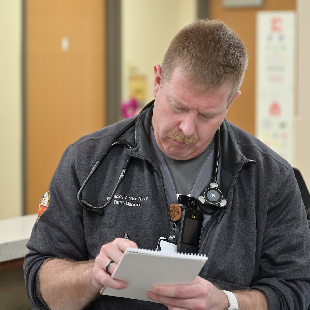 Navy Lt. Bradley Vander Zanden, a family medicine resident at Carl R. Darnall Army Medical Center, writes notes while speaking to a nurse. Residents at the hospital train across multiple specialties while caring for service members, retirees, and their families.