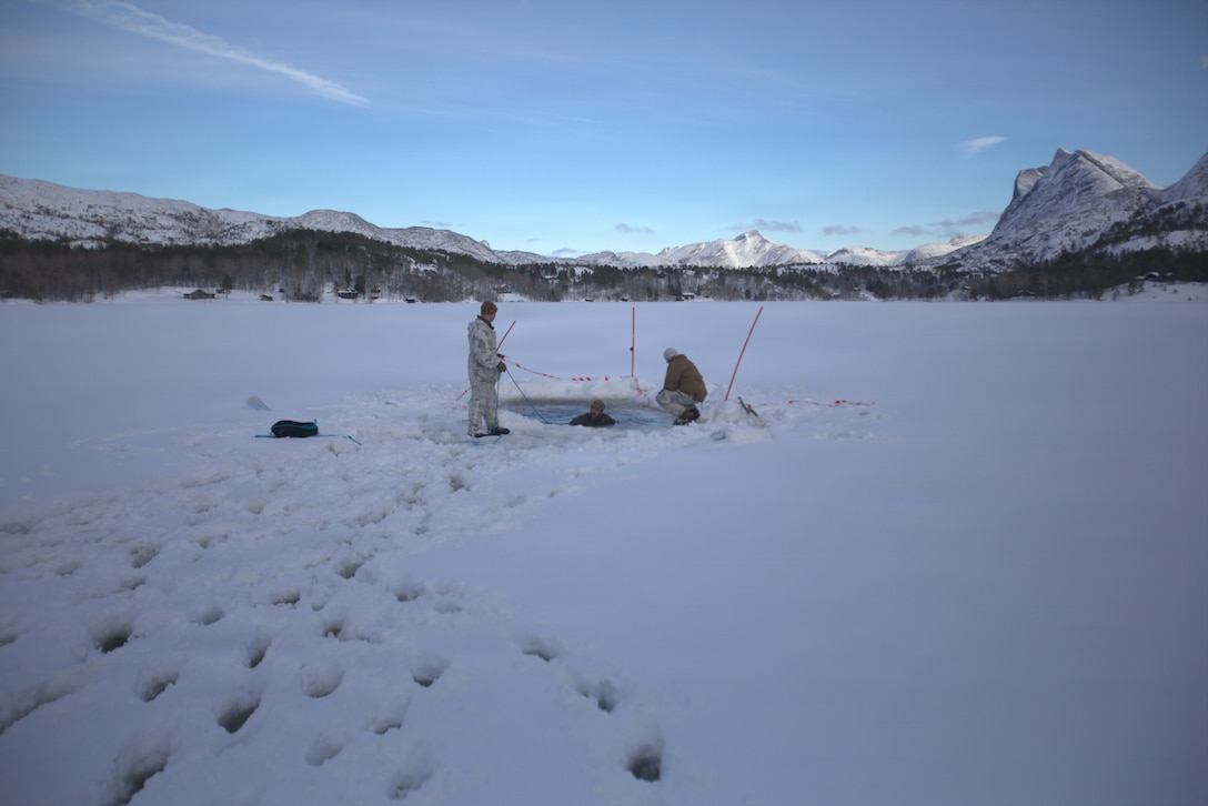 U.S. Marine Corps Staff Sgt. Richard Angel, left, a transmissions chief with Marine Wing Communications Squadron (MWCS) 28, Marine Air Control Group 28, 2nd Marine Aircraft Wing, and 2nd Lt. Ethan Robinson, right, a military police officer with 2nd MAW, observe Sgt. Aubron Thomas, a digital wideband systems maintainer with MWCS-28, during an ice-breaker drill as part of exercise Cold Response 26 near Bodø Air Station, Norway, Feb. 26, 2026. A key component of NATO's enhanced vigilance activity Arctic Sentry, exercise Cold Response 26 is a Norwegian-led winter military exercise designed to enhance collective defense capabilities and ensure U.S. readiness to rapidly deploy and seamlessly operate alongside NATO Allies in challenging arctic conditions. Angel is a native of Florida, Robinson is a native of Missouri, and Thomas is a native of Louisiana. (U.S. Marine Corps photo by 1st Lt. John Graham)