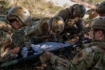 Students from the Rogers Airman Leadership School based out of Joint Base San Antonio-Lackland, Texas, secure a simulated victim to a litter during the newly developed Airman Leadership School – Field Training Exercise on JBSA-Camp Bullis, Texas, Feb. 5, 2026. During the ALS-FTX students responded to a simulated base attack, transported simulated injured personnel and provided initial medical care to simulated victims, while utilizing skills learned in the ALS curriculum such as critical thinking and team building. (U.S. Air Force photo by Joshua J. Garcia)