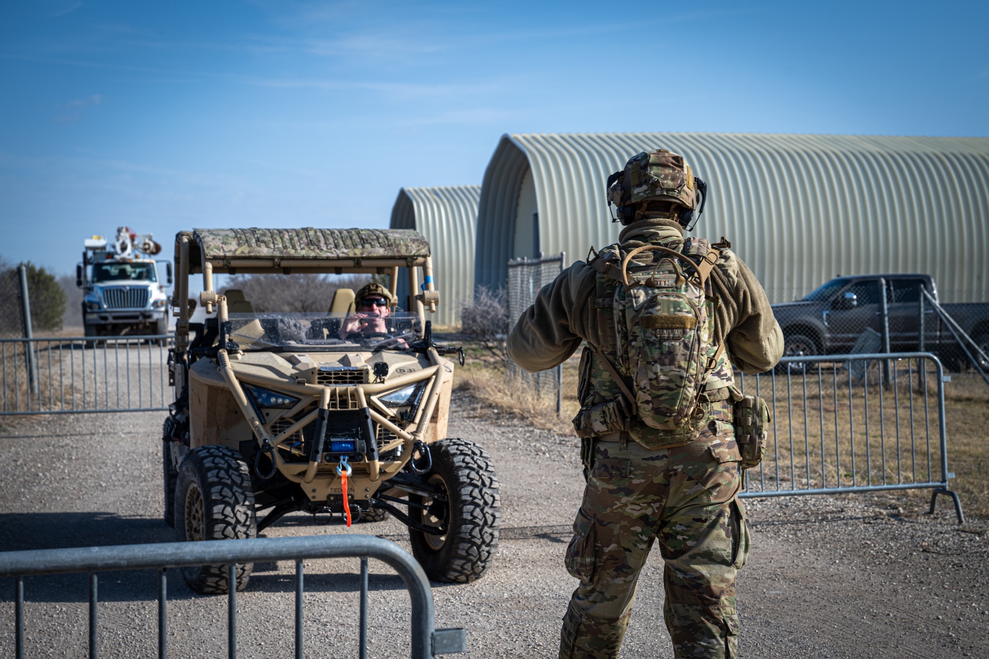 U.S. Air Force Staff Sgt. Charles Scott Jr., 21st Combat Air Base Squadron electrical team lead, confronts a vehicle at an entry control point during exercise Bamboo Eagle 26-1 at Dyess Air Force Base, Texas, Feb. 20, 2026. Maintaining security in a training environment ensures Airmen are prepared to counter threats during real-world operations in austere locations. (U.S. Air Force photo by Airman 1st Class Adrien Tran)