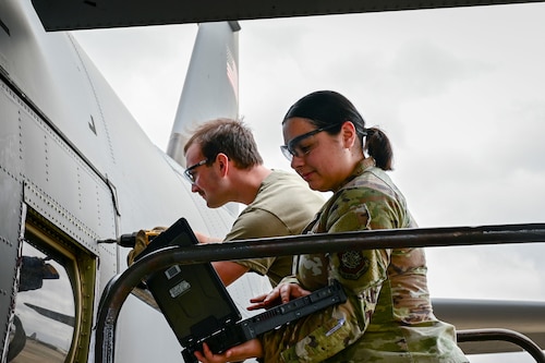 U.S. Air Force Airman 1st Class Ariana Alston, right, 19th Logistics Readiness Squadron customer service journeyman, assists Airman 1st Class Samuel Keenum, left, 19th Aircraft Maintenance Squadron C-130J journeyman crew chief, during a para-trooper door window repair on a C-130J Super Hercules aircraft at Little Rock Air Force Base, Arkansas, Feb. 17, 2026. The task was conducted as part of a Maintenance Supply Immersion Program designed to improve communication and strengthen teamwork between maintenance and materiel management personnel.