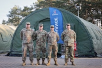 Illinois Army National Guard Soldiers with the Springfield, Ill.-based 232nd Combat Sustainment Support Battalion, pose in front of the Army & Air Force Exchange Authorized Imprest Fund Activity (AIFA) PX they run in Karliki, Poland.