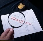 A magnifying glass enhances the fine print of a contract. The word "Fraudulent" is overlayed