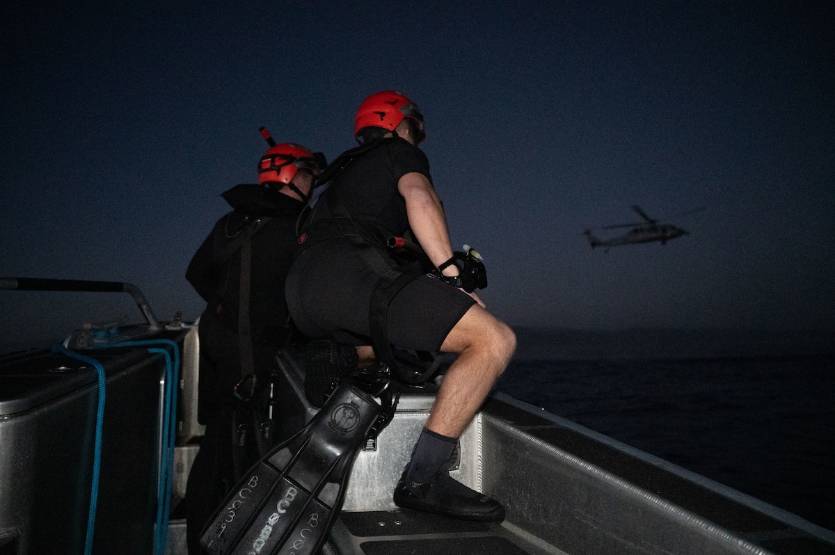 U.S. Navy rescue swimmers observe an HH-60H Seahawk participating in Exercise Bamboo Eagle 26-1 off the coast of San Diego, California, Feb. 13, 2026. The exercise tests advanced tactics and operational concepts, ensuring the joint force remains prepared to respond decisively to global challenges and contested environments. (U.S. Air Force photo by Airman 1st Class Jaden Kidd)