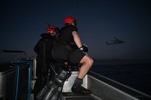 U.S. Navy rescue swimmers observe an HH-60H Seahawk participating in Exercise Bamboo Eagle 26-1 off the coast of San Diego, California, Feb. 13, 2026. The exercise tests advanced tactics and operational concepts, ensuring the joint force remains prepared to respond decisively to global challenges and contested environments. (U.S. Air Force photo by Airman 1st Class Jaden Kidd)