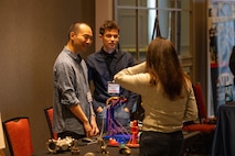 NORTH BETHESDA, Md. (Feb. 26, 2026) – University of Maryland students George Hwang, left, and Benicio Nix showcase their project, a 3D scanner mounted on a robotic arm, during the SIDE 2026: A Deep Dive into 3D Scanning industry partnership forum. The event, co-hosted by the Carderock Capital Tech Bridge and the Pike District Partnership, provided a platform for students to demonstrate their work and network with professionals from government, industry, and academia. Carderock, the Navy's innovation and ship design powerhouse, headquartered in West Bethesda, Maryland, is a world-class research and development facility specializing in critical ship and ship systems design.  (U.S. Navy photo by Aaron Thomas)
