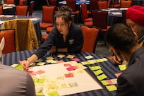 Rayna Roades, a student panelist from Northern Virginia Community College, participates in a Collaboration Workshop during the SIDE 2026: A Deep Dive into 3D Scanning industry partnership forum. Roades and other attendees, including industry leaders and personnel from Naval Surface Warfare Center, Carderock Division, used sticky notes to brainstorm and discuss potential partnership opportunities.