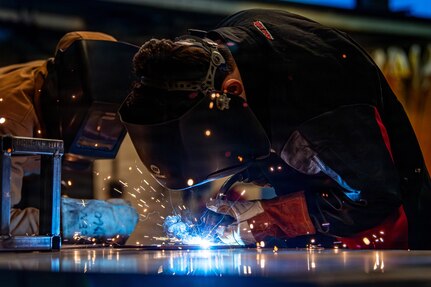 Airmen welding metal