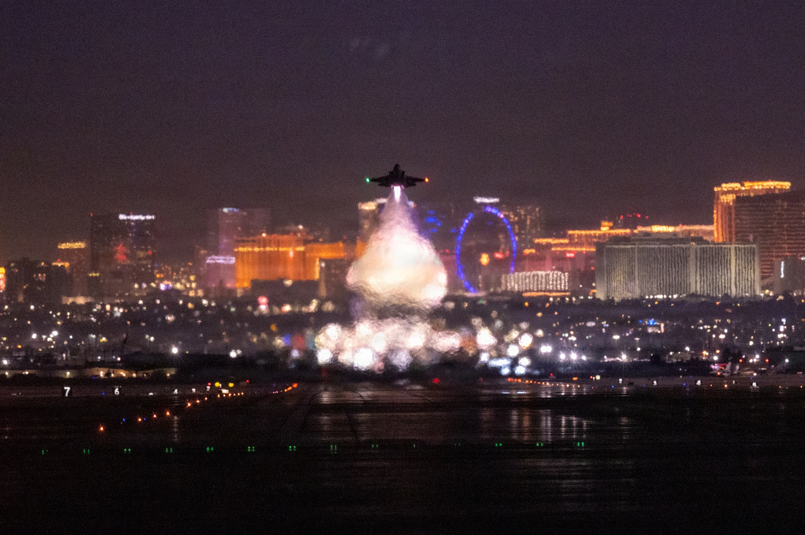 F-22 taking off at night with Las Vegas strip in background