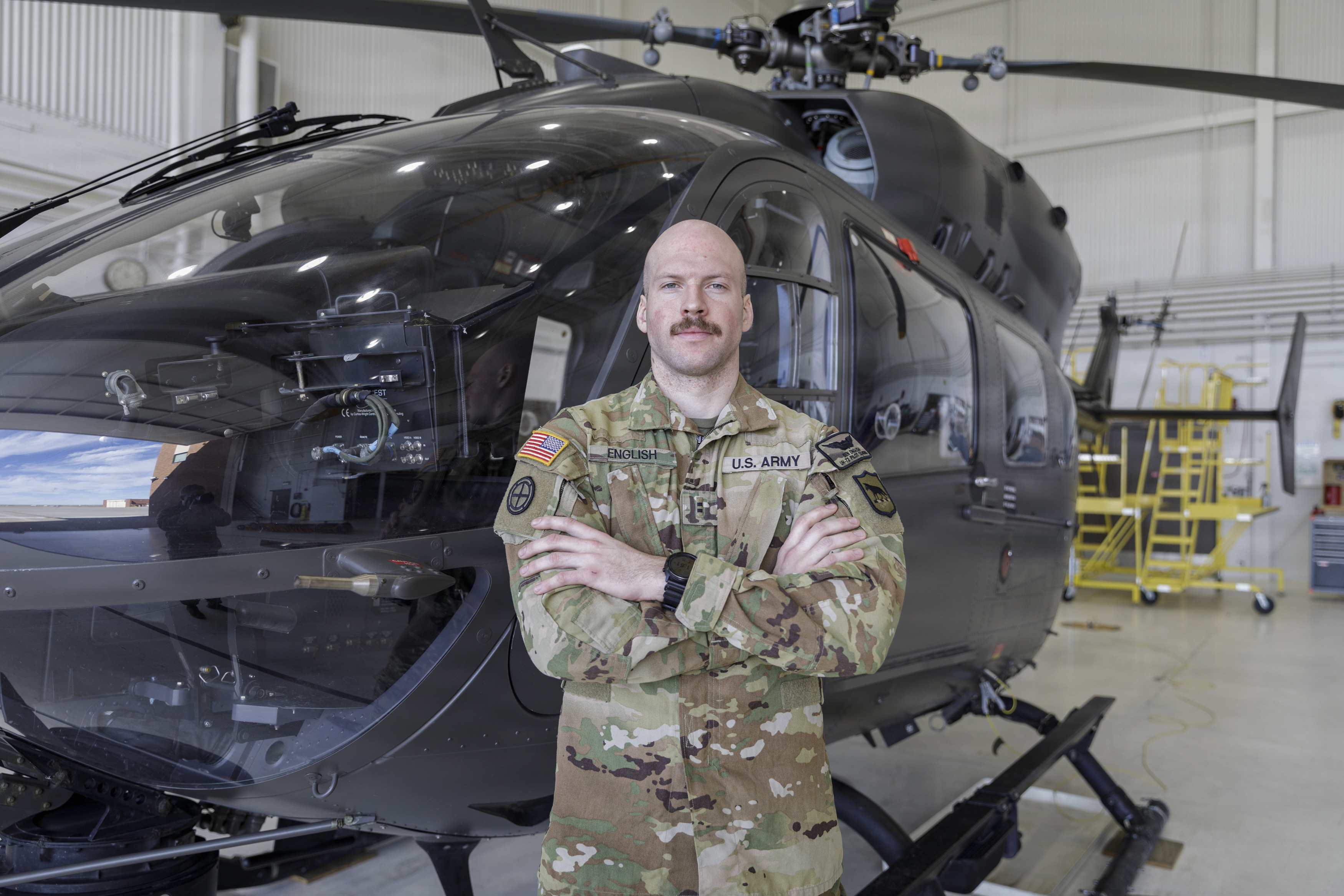Chief Warrant Officer 2 Ben English, a LUH-72 Lakota helicopter pilot with Bravo Company, 1st Battalion, 112th Aviation Regiment, South Dakota Army National Guard, poses for a portrait in front of a LUH-72 Lakota helicopter in Rapid City, South Dakota, Feb. 7, 2026.