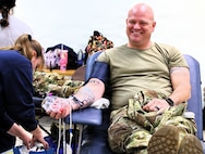 Illinois Army National Guard Sgt. 1st Class Joshua Webb of Galesburg's C Battery, 2nd Battalion, 123rd Field Artillery Regiment smiles as he prepares to let the blood flow for donation at the Illinois Army National Guard's armory in Milan.