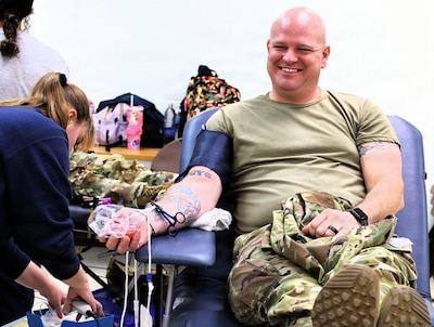 Illinois Army National Guard Sgt. 1st Class Joshua Webb of Galesburg's C Battery, 2nd Battalion, 123rd Field Artillery Regiment smiles as he prepares to let the blood flow for donation at the Illinois Army National Guard's armory in Milan.