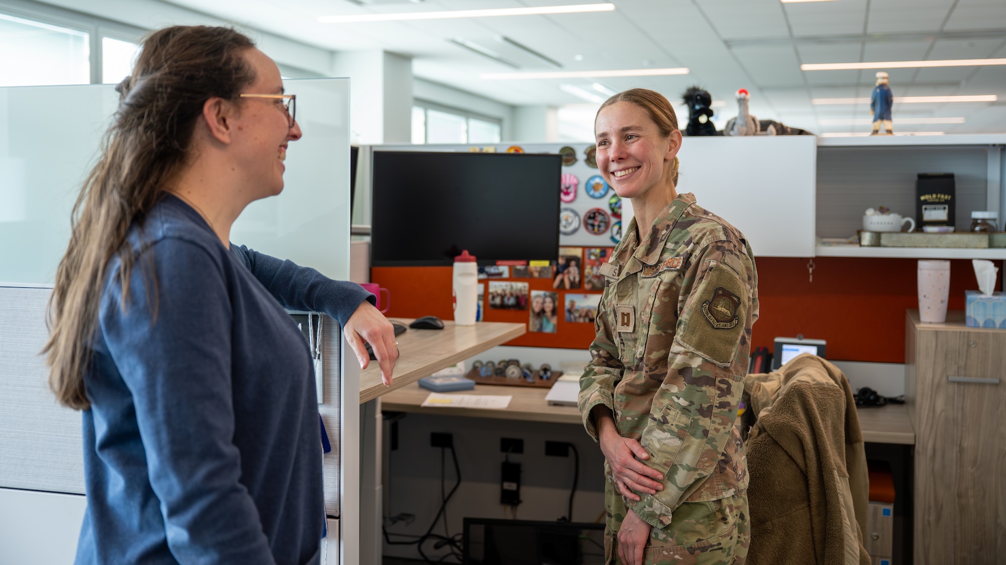 Capt. Jaci Smith, an Aircraft Analysis Squadron analyst, smiles while speaking with her coworker, Dr. Annie Tufts, at Wright-Patterson Air Force Base, Ohio, Feb. 20, 2026. Smith credits the support of her colleagues and leadership as a key factor in her ability to balance a demanding career while training for the upcoming World Military Cross Country Championship. (U.S. Air Force photo by Staff Sgt. Kristof J. Rixmann)