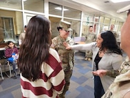 Claudia Morales pins staff sergeant rank on her sister, Daniela Martinez.