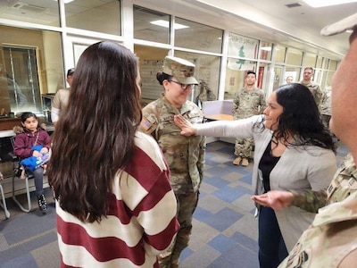 Claudia Morales pins staff sergeant rank on her sister, Daniela Martinez.