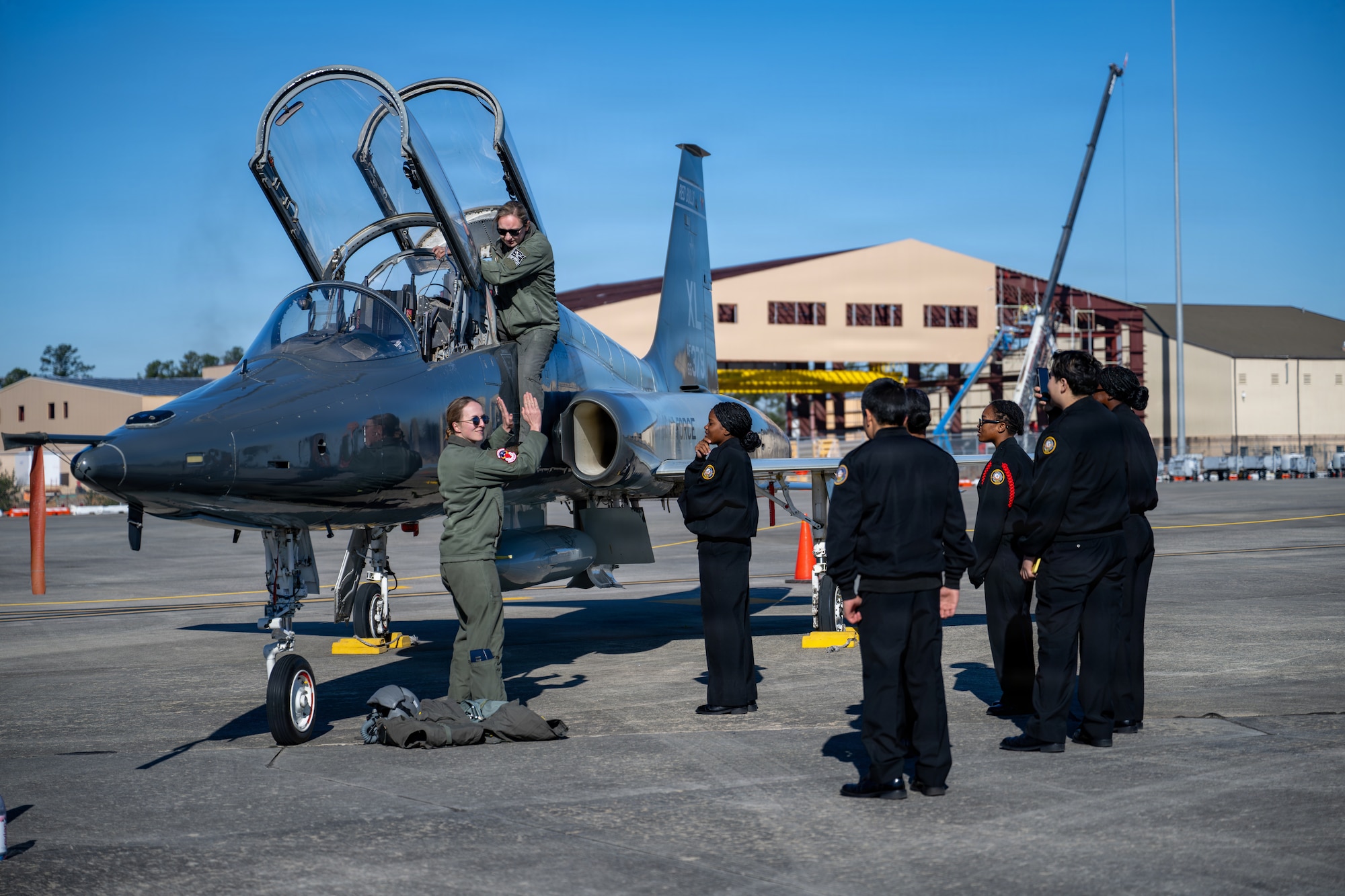 Two U.S. Air Force T-38 Talon pilots stationed with the 87th Flying Training Squadron (FTS), give a tour of the aircraft to Navy ROTC students during Saluting Our Aviation Roots (SOAR) Week at Moody Air Force Base, Georgia, Feb. 24, 2026. Students from the local area converged on the air base hearing from all career fields from pilots to firemen and more. (U.S. Air Force photo by Airman 1st Class Rachel Howell)