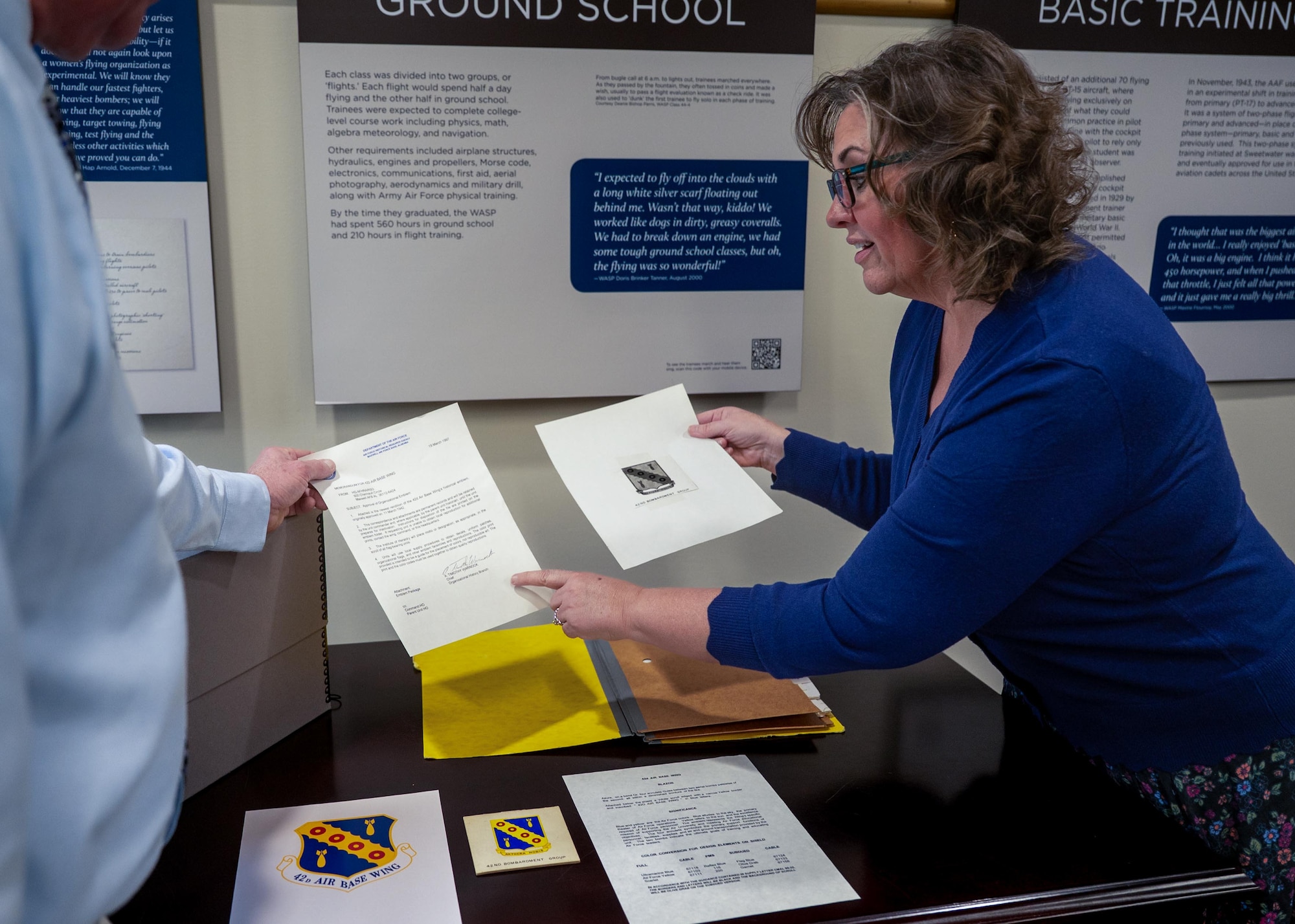 Melissa Lahue, Air Force Historical Research Agency research division chief, and Samuel Shearin, AFHRA lineage, honors and heraldry division historian, demonstrate and explain the importance of the linage of the 42d Air Base Wing’s emblem at Maxwell Air Force Base, Alabama, Feb. 26, 2026