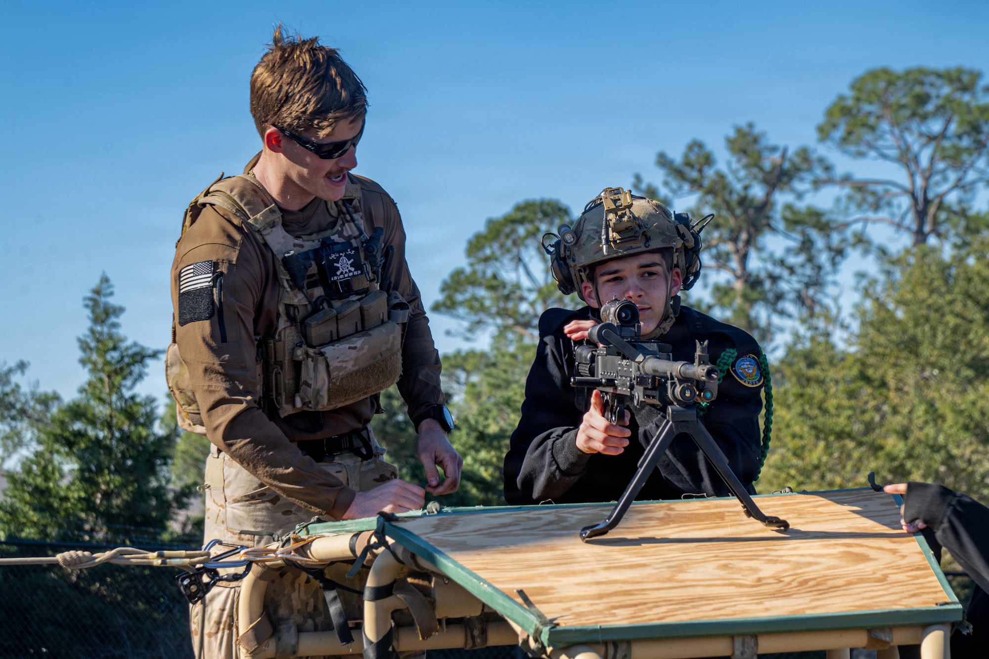 A U.S. Air Force Airman assigned to the 23d Wing allows a Navy Junior Reserve Officer Training Corps cadet to simulate handling a weapon during the Saluting Our Aviation Roots (SOAR) static display at Moody Air Force Base, Georgia, Feb. 24, 2025. SOAR allowed Navy Cadets to learn about the Air Force’s mission capabilities. (U.S. Air Force photo by Airman 1st Class Noah Noonan)