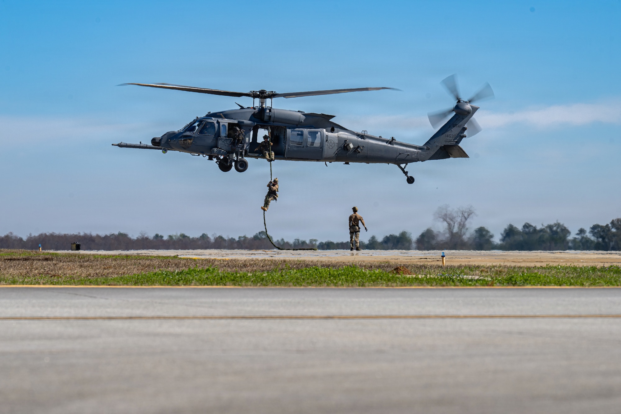 U.S. Air Force Airmen assigned to the 41st Rescue Squadron and the 38th Rescue Squadron simulate rescue operations during an aerial demonstration at Saluting Our Aviation Roots (SOAR) at Moody Air Force Base, Georgia, Feb. 24, 2025. SOAR allowed Airmen to engage with community members to allow them to learn more about the Air Force. (U.S. Air Force photo by Airman 1st Class Noah Noonan)